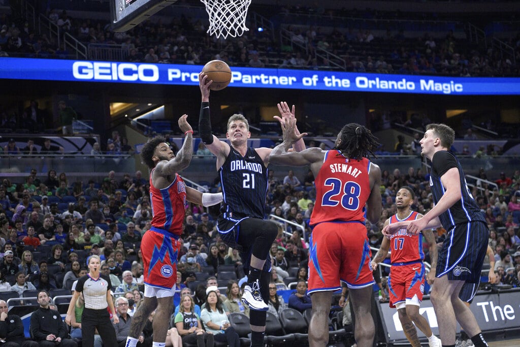 Media by Associated Press - Orlando Magic center Moritz Wagner (21) goes up for a shot between Detroit Pistons forward Saddiq Bey, left, and center Isaiah Stewart (28) as guard Rodney McGruder (17) and Magic forward Franz Wagner, right, watch during the second half of an NBA basketball game, Thursday, March 17, 2022, in Orlando, Fla. (AP Photo/Phelan M. Ebenhack)