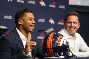 Media by Associated Press - Denver Broncos quarterback Russell Wilson, left, laughs as he describes a late-night video call to general manager George Paton, right, during a news conference to announce that Wilson had signed a five-year contract extension worth $245 million, Thursday, Sept. 1, 2022, at the NFL football team's headquarters in Centennial, Colo. (AP Photo/David Zalubowski)