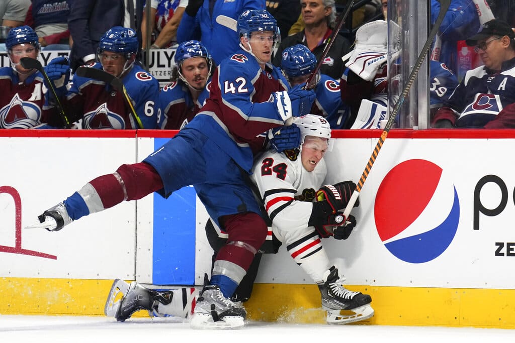 Media by Associated Press - Colorado Avalanche defenseman Josh Manson (42) checks Chicago Blackhawks center Sam Lafferty (24) into the boards during the third period of an NHL hockey game Wednesday, Oct. 12, 2022, in Denver. The Avalanche won 5-2. (AP Photo/Jack Dempsey)