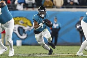 Media by Associated Press - Jacksonville Jaguars running back Travis Etienne Jr. (1) runs the ball during an NFL wild-card football game against the Los Angeles Chargers, Saturday, Jan. 14, 2023, in Jacksonville, Fla. The Jaguars defeated the Chargers 31-30. (AP Photo/Gary McCullough)