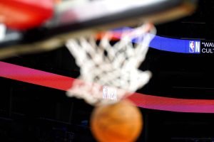 Media by Associated Press - A basketball drops through the net with the NBA logo in the background before a preseason basketball game with the Phoenix Suns and the Adelaide 36ers Sunday, Oct. 2, 2022, in Phoenix. (AP Photo/Darryl Webb)