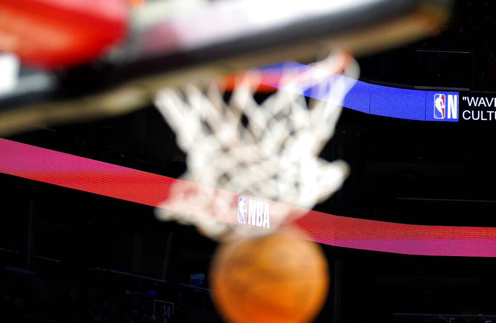 Media by Associated Press - A basketball drops through the net with the NBA logo in the background before a preseason basketball game with the Phoenix Suns and the Adelaide 36ers Sunday, Oct. 2, 2022, in Phoenix. (AP Photo/Darryl Webb)