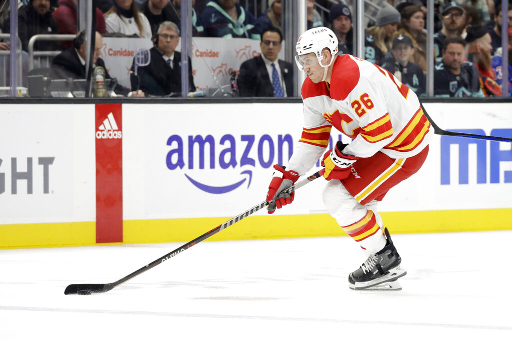 Media by Associated Press - Calgary Flames defenseman Michael Stone (26) skates with the puck against the Seattle Kraken during the second period of an NHL hockey game, Friday, Jan. 27, 2023, in Seattle. (AP Photo/John Froschauer)