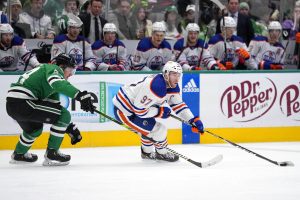 Media by Associated Press - Edmonton Oilers center Connor McDavid (97) controls the puck as Dallas Stars center Roope Hintz follows behind in the second period of an NHL hockey game, Wednesday, Dec. 21, 2022, in Dallas. (AP Photo/Tony Gutierrez)