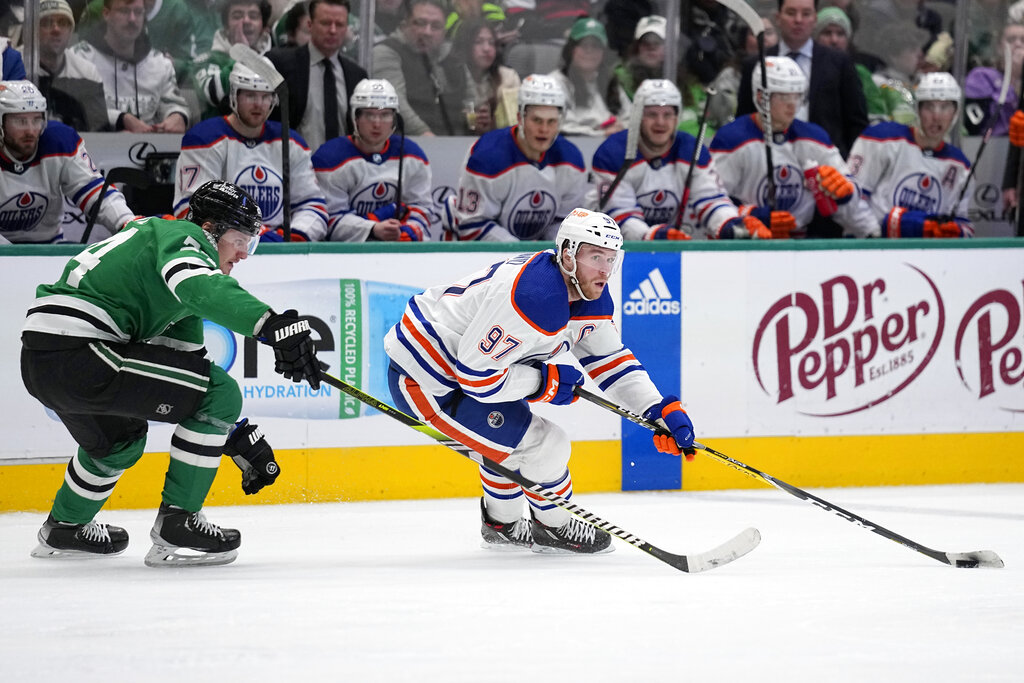 Media by Associated Press - Edmonton Oilers center Connor McDavid (97) controls the puck as Dallas Stars center Roope Hintz follows behind in the second period of an NHL hockey game, Wednesday, Dec. 21, 2022, in Dallas. (AP Photo/Tony Gutierrez)