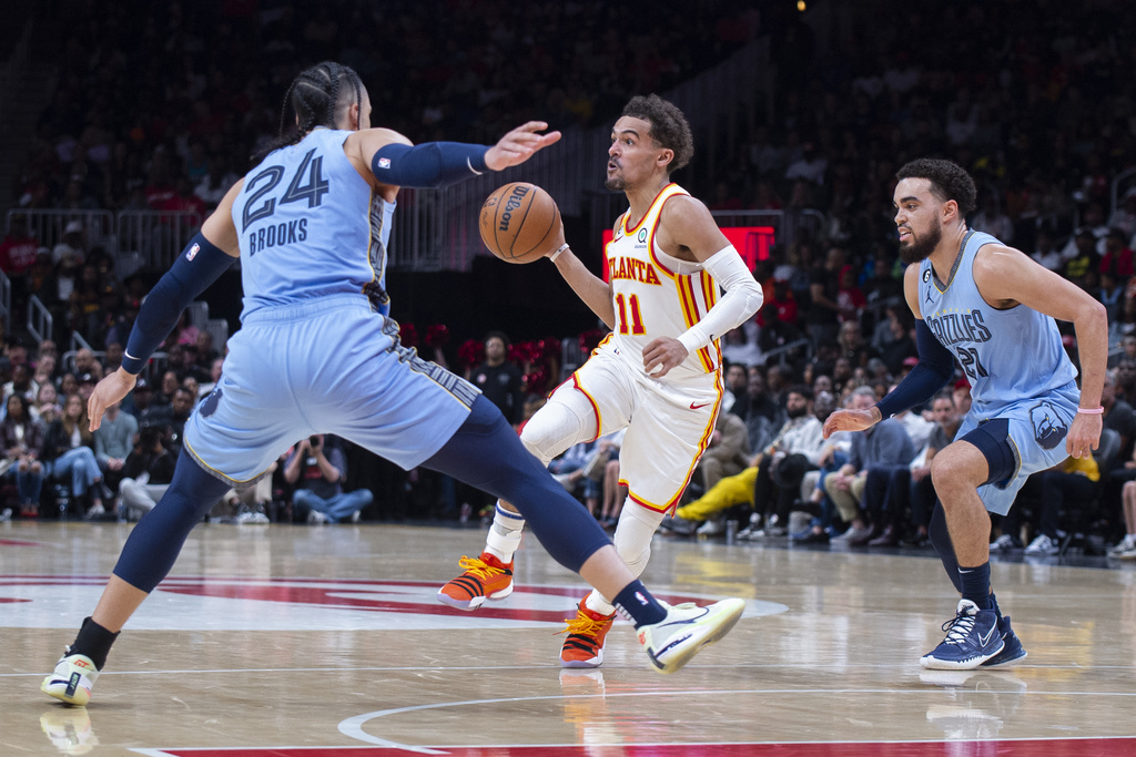 Media by Associated Press - Atlanta Hawks guard Trae Young looks to pass between Memphis Grizzlies forward Dillon Brooks and guard Tyus Jones during the second half of an NBA basketball game, Sunday, March 26, 2023, in Atlanta. (AP Photo/Hakim Wright Sr.)